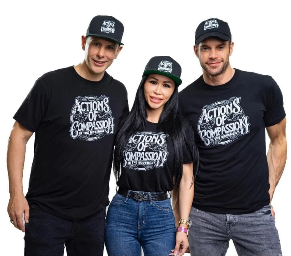 Three people wearing Actions of Compassion shirts and caps