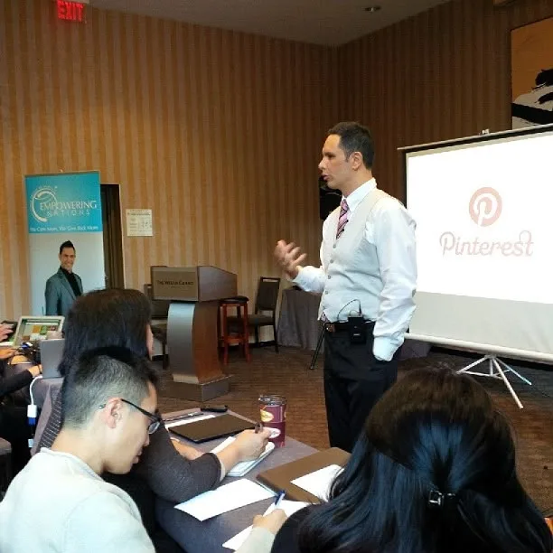 Shane James presenting to a seated workshop audience beside a Pinterest slide